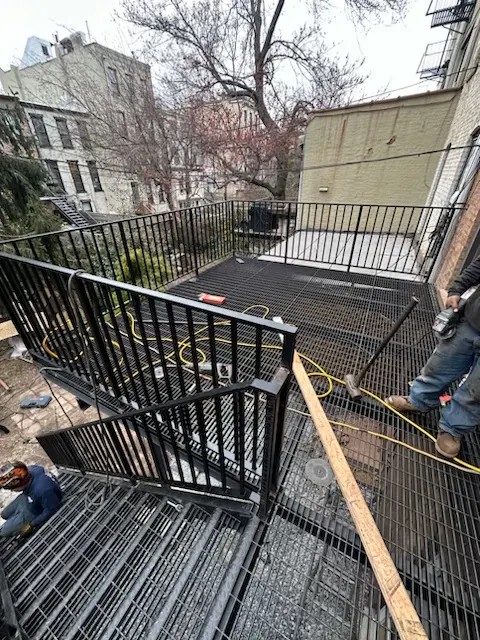 Custom iron works Brooklyn — pipe railing installation on residential brownstone stoop